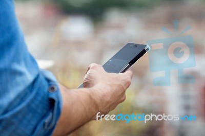 Man Hand Holding Mobile Phone In The City Stock Photo