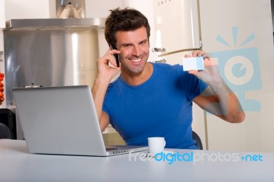 Man In Kitchen With Laptop Stock Photo
