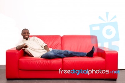 Man On The Sofa With Remote Control Stock Photo