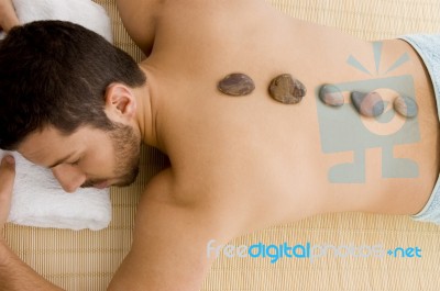 Man Relaxing With Stone Treatment Stock Photo