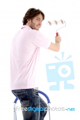 Man Standing On Chair And Holding Paint Roller Stock Photo