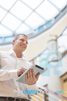 Man With Tablet Computer In Modern Business Building Stock Photo
