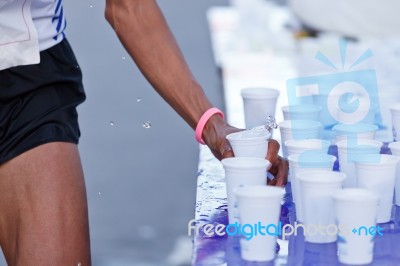 Marathon Racer Catching Cup Of Water Stock Photo