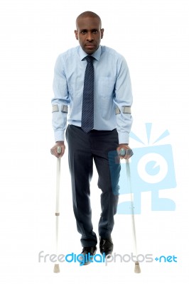 Middle Aged Man Walking With Two Crutches Stock Photo
