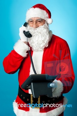 Modern Santa Passing Greetings Over A Phone Call Stock Photo