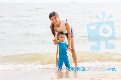 Mom And Son Chill On The Beach Stock Photo