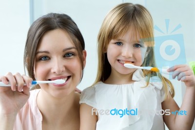 Mother And Daughter Brushing Teeth In The Bathroom Stock Photo