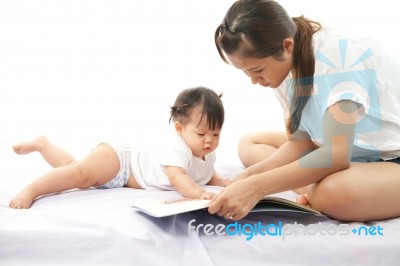 Mother Is Reading A Book For Her Baby Stock Photo