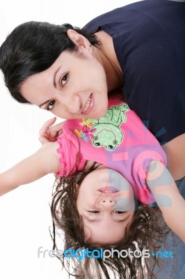 Mother Playing With Her Daughter And Holding Her Upside Down Stock Photo