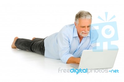 Old Man Lying With Laptop Computer Stock Photo