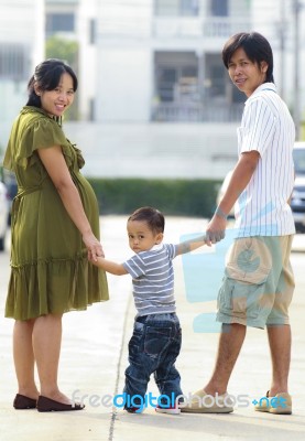 Parents Holding Hand Of His Son In Outdoors Stock Photo