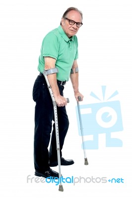 Physically Disabled Old Man With Crutches Stock Photo