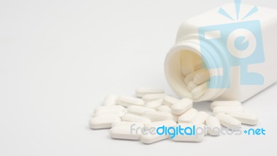 Pills Scattered From Plastic Container Stock Photo