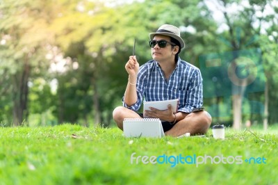 Portrait Of A Concentrated Casual Man In Hat Holding Notebook An… Stock Photo