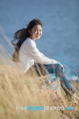 Portrait Of Asian Teenager Relaxing On Natural Field Stock Photo