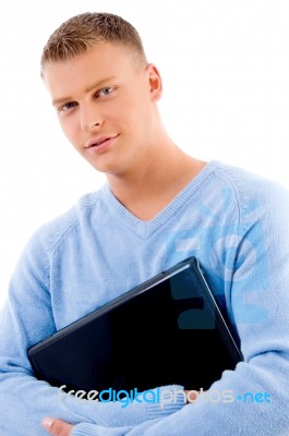 Portrait Of Smiling Young Man Holding Laptop Stock Photo