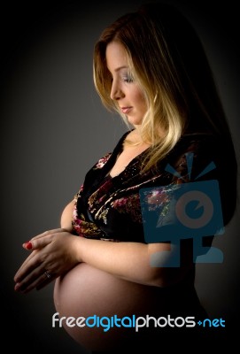 Pregnant Female With Joined Hands Stock Photo