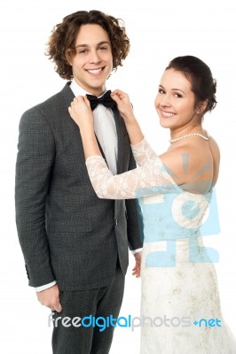 Pretty Bride Adjusting Her Man's Bowtie Stock Photo