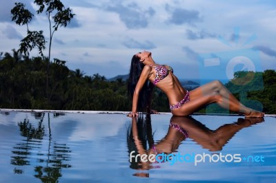 Pretty Brunette Model In Bikini Posing At The Pool Stock Photo