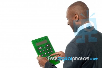 Rear View Of Businessman Using Calculator Stock Photo