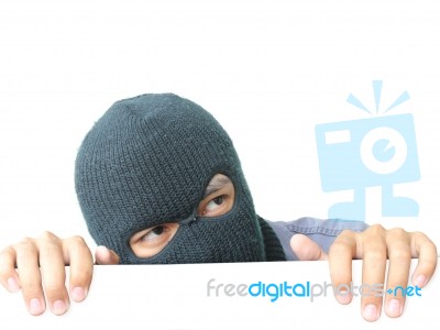 Robber Hiding Under A White Wall Stock Photo