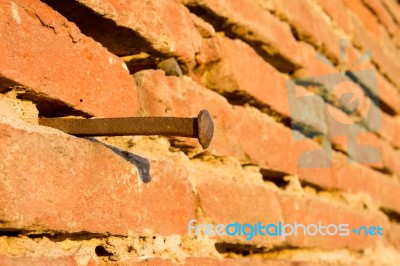 Rusty Nail On Brick Wall Stock Photo