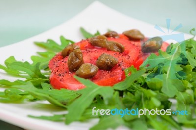 Salad With Fresh Tomatoes, Capers And Arugula Stock Photo