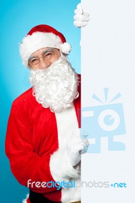 Santa Posing Beside Long Blank Banner Ad Stock Photo