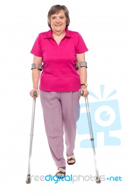 Senior Lady Walking With Crutches Stock Photo