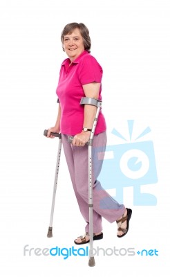 Senior Lady Walking With Crutches Stock Photo