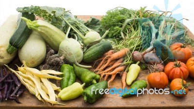 Several Vegetables On Wooden Chopping Board And Table Stock Photo