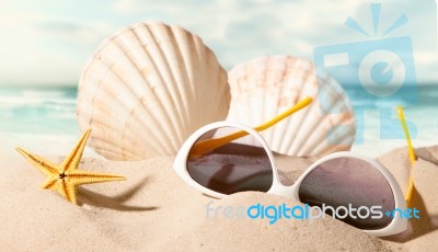 Shell With Sunglasses On Beach Stock Photo