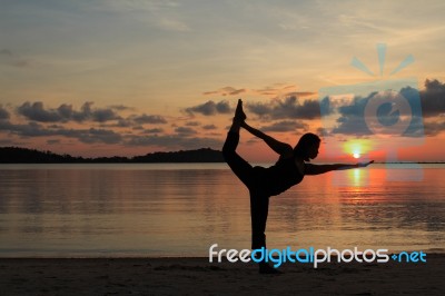Silhouette Of Yoga Girl At Sunrise On The Beach Stock Photo