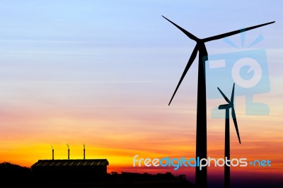 Silhouette Wind Turbine Generator With Factory Emissions Of Carb… Stock Photo