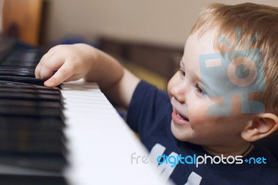 Small Boy Enjoys Playing Electric Piano Stock Photo