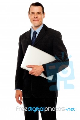 Smiling Businessman Holding Laptop Stock Photo