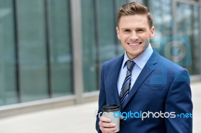 Smiling Businessman With Coffee Sipper Stock Photo