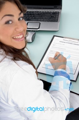 Smiling Doctor Holding Pen And Looking At Camera Stock Photo