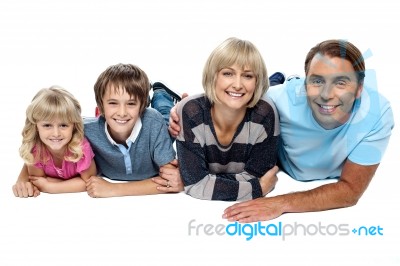 Smiling Family Of Four Relaxing On White Background Stock Photo