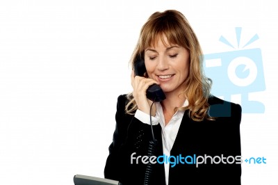 Smiling Female Executive Attending Phone Call Stock Photo