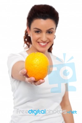 Smiling Lady Offering You An Orange Stock Photo