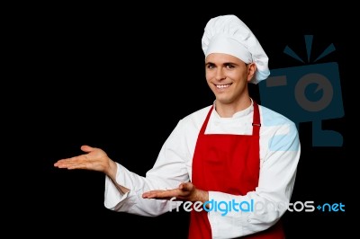 Smiling Male Chef Presenting Something Stock Photo