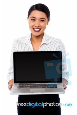 Smiling Saleswoman Presenting Brand New Laptop Stock Photo