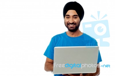 Smiling Young Guy Using His Laptop Stock Photo