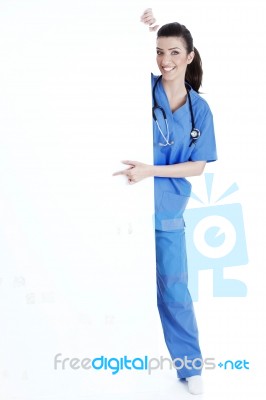Smiling Young Nurse Pointing Blank Board Stock Photo