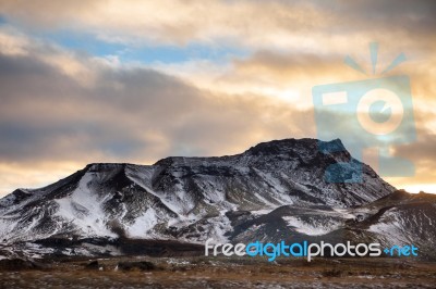Snowy Icelandic Mountains With Dramatic Cloudy Sky Stock Photo