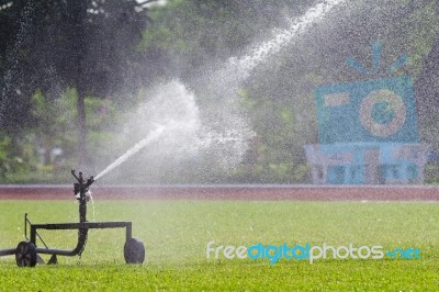 Sprinkler Watering The Grass Stock Photo