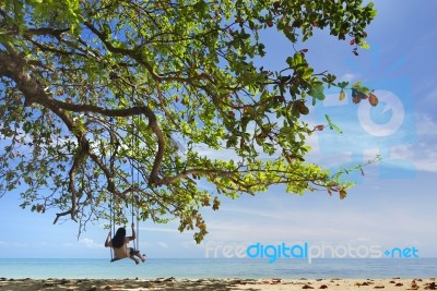 Swing Under Tree And Sea Stock Photo