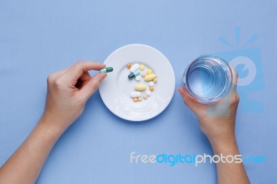 Taking Pill With Pills On Plate Stock Photo