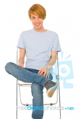 Teenage Boy Sitting On Chair Stock Photo